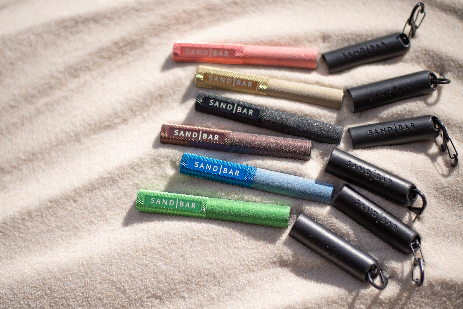 SandBar Quickie Callus files laying in the sand with there magnetic caps and s clips to show off the different colors they offer.