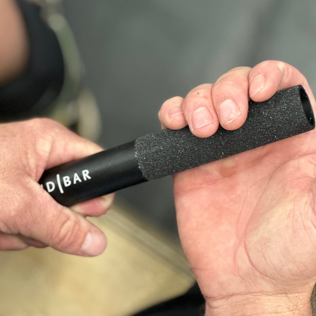 Hand gripping onto the Sandbar callus file, and rotating it in their hand to file down their calluses.