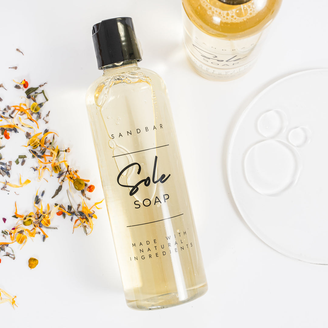 Two bottles of Sandbar Sole Soap on a white background with dried flowers.