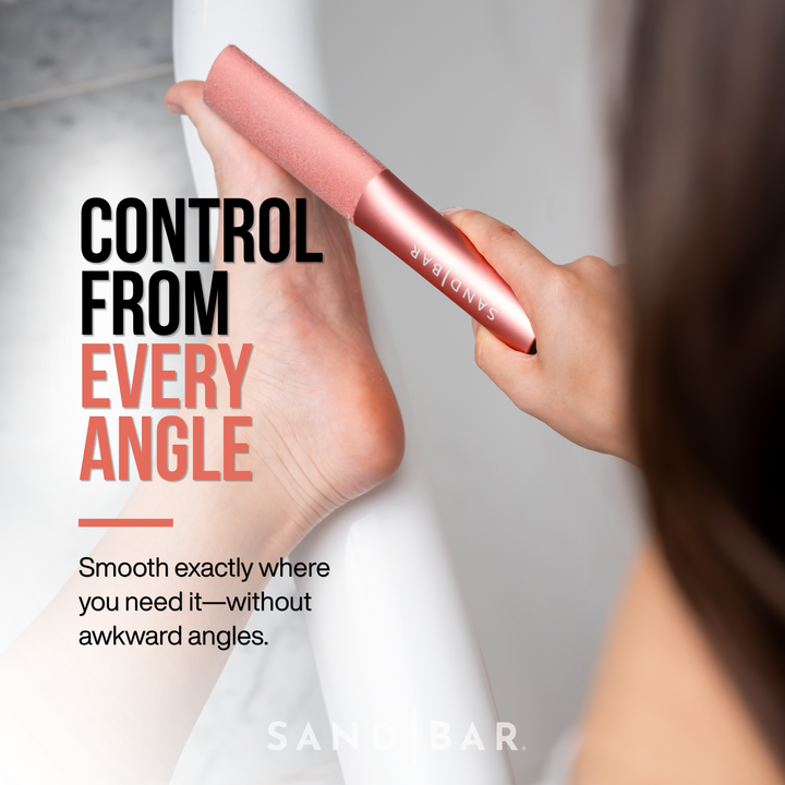 Woman using SandBar copper pink colored foot file on side of her big toe with ergonomic grip for precise smoothing from every angle.