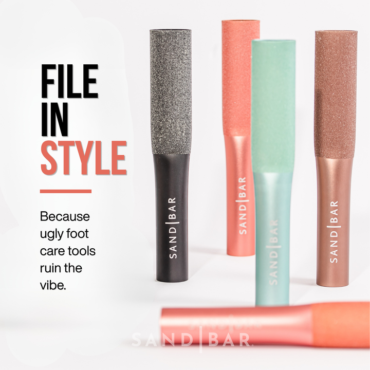 Sleek aluminum SandBar foot files in multiple colors, pink, turquoise, dark gray and taupe, designed as stylish modern foot care tools.