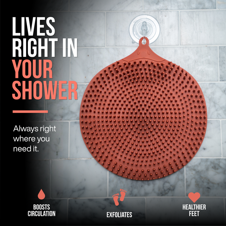 SandBar silicone circular foot exfoliating pad with raised massage nubs, hanging in a shower with suction hook, designed for convenient everyday use and easy storage. The image includes promotional text reading 'LIVES RIGHT IN YOUR SHOWER' and feature callouts for circulation, exfoliation, and healthier feet.