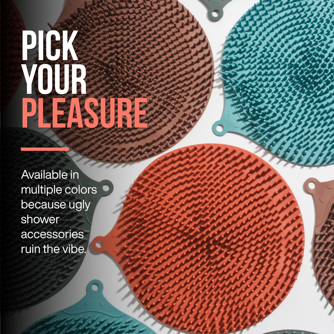 Promotional graphic showing several round silicone SandBar shower foot scrubbing mats in different colors, including a rusty pink, turquoise, dark gray and taupish color. Large text reads 'PICK YOUR PLEASURE' and smaller text says 'Available in multiple colors because ugly shower accessories ruin the vibe.