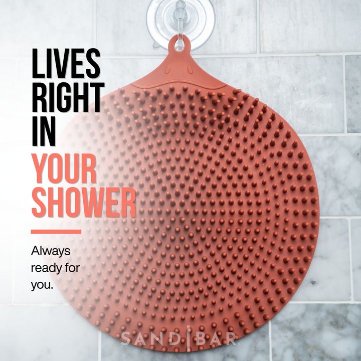 Silicone foot scrubber mat hanging in shower with suction hook for daily use